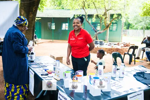 A volunteer at the foundation's merchandise stall talking with a visitor