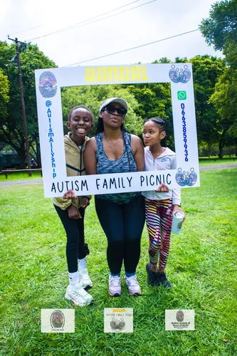 A mother and her two daughters posing together at the picnic